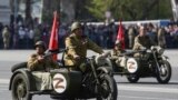 RUSSIA - Participants wearing historical uniforms ride in WWII-era motorcycles adorned with stickers of the letter Z during a military parade in Novosibirsk, 9MAY2022