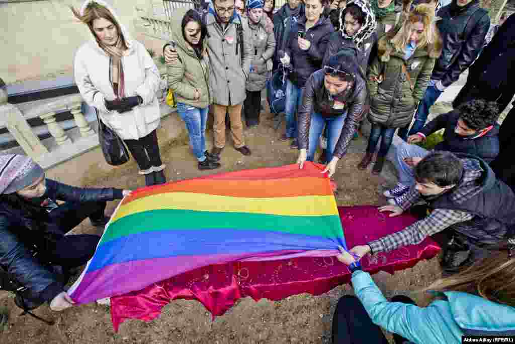 Dostları LGBT bayrağını məzar üzərinə sərir.