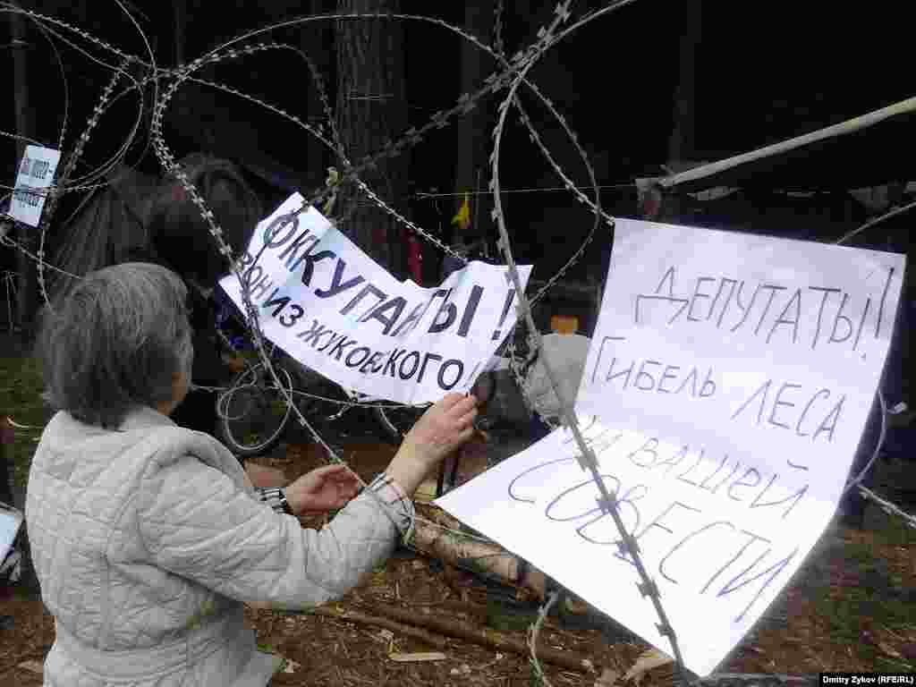 Крепят плакаты к колючей проволоке 