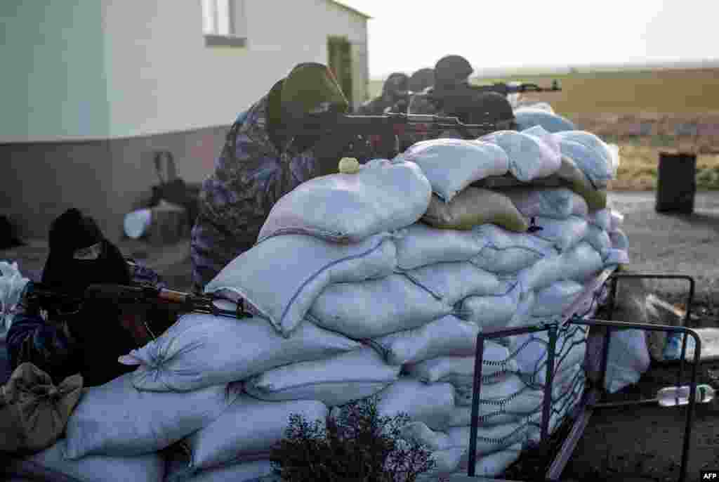 Ukraine -- Armed pro-Russian servicemen stand guard at Chongar checkpoint blocking the entrance to Crimea, March 10, 2014