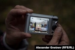 Нина Шалаева показывает фотографию полицейских, приезжавших в лагерь